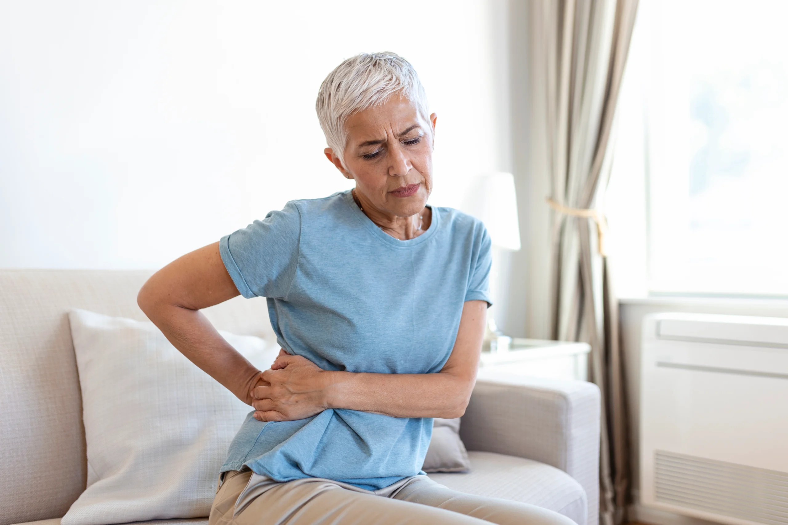 unhealthy-mature-woman-holding-belly-feeling-discomfort-health-problem-concept-unhappy-older-female-sitting-bed-suffering-from-stomachache-food-poisoning-gastritis-abdominal-pain-climax